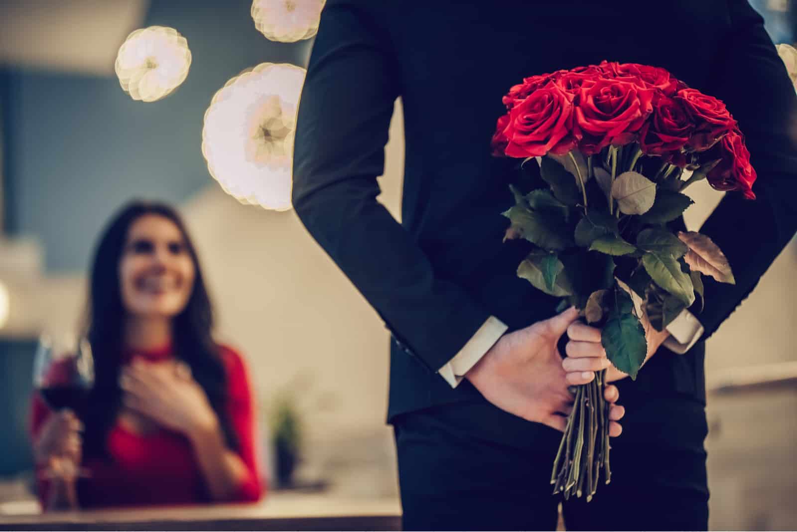 un homme a surpris une femme avec un bouquet de roses rouges