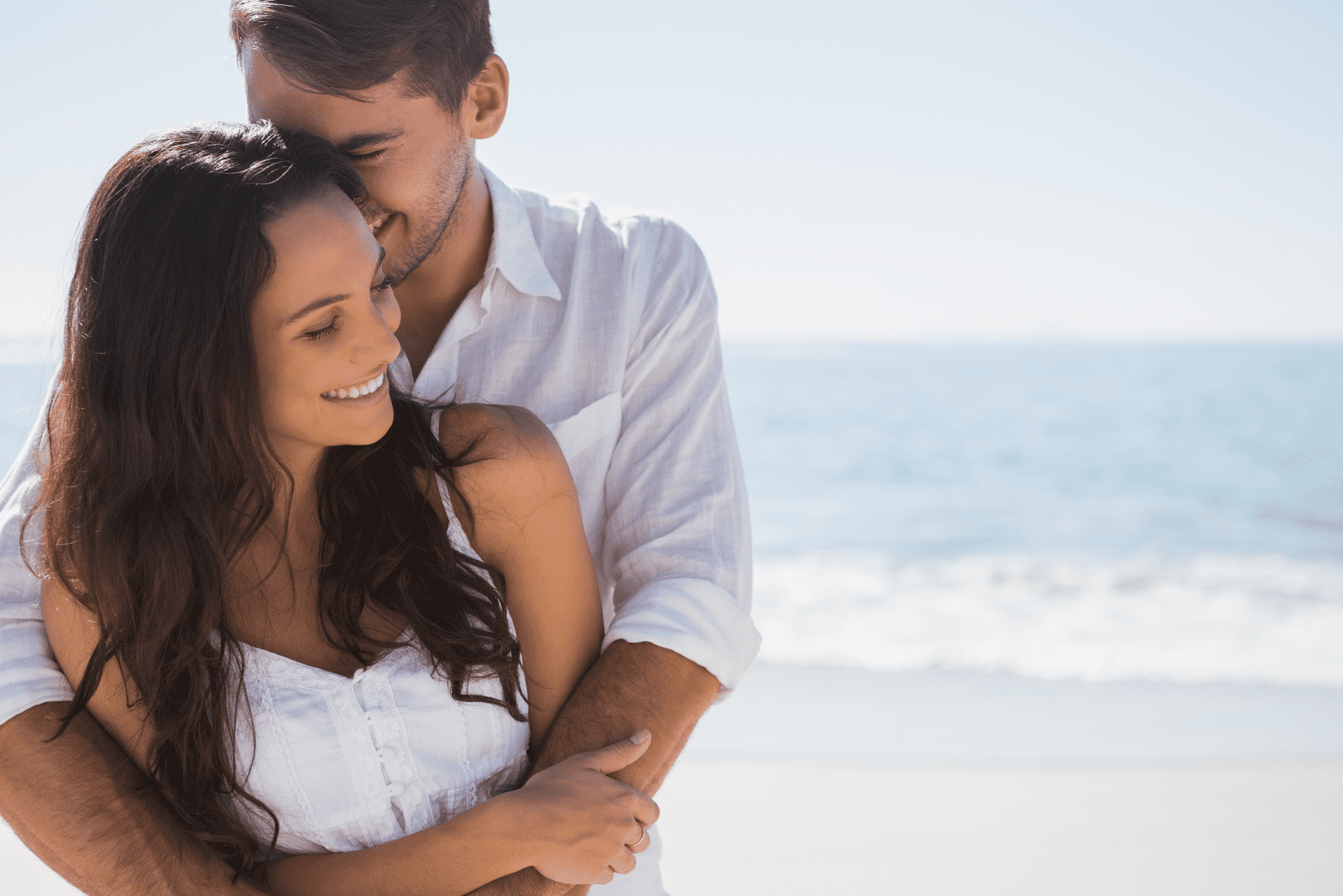 un homme souriant a embrassé une femme sur la plage