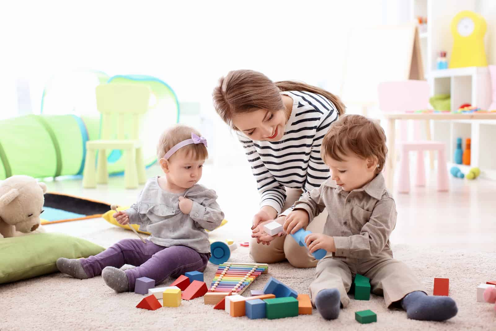 une femme joue avec deux enfants dans la maison