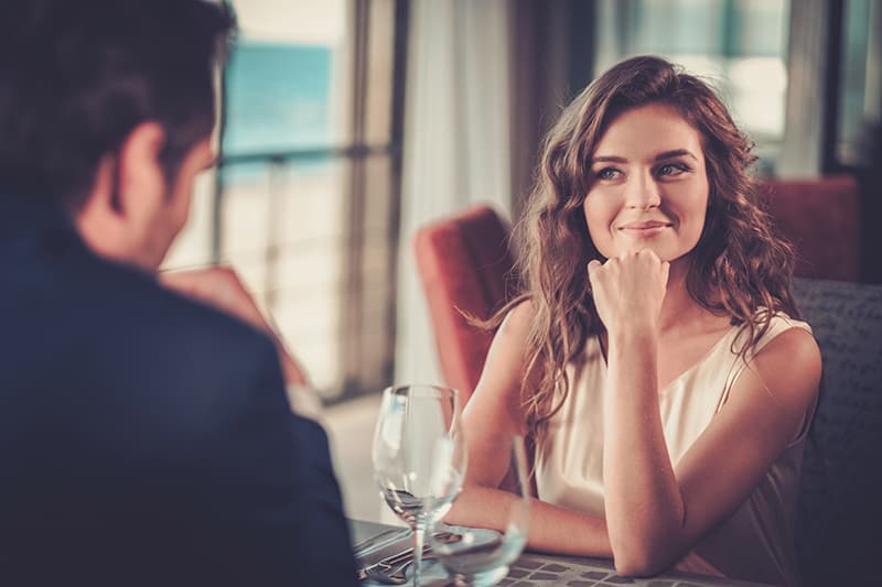 une femme souriante écoutant attentivement un homme dans un restaurant