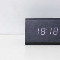 Horloge numérique noire sur fond blanc indiquant l'heure 18:18 minutes