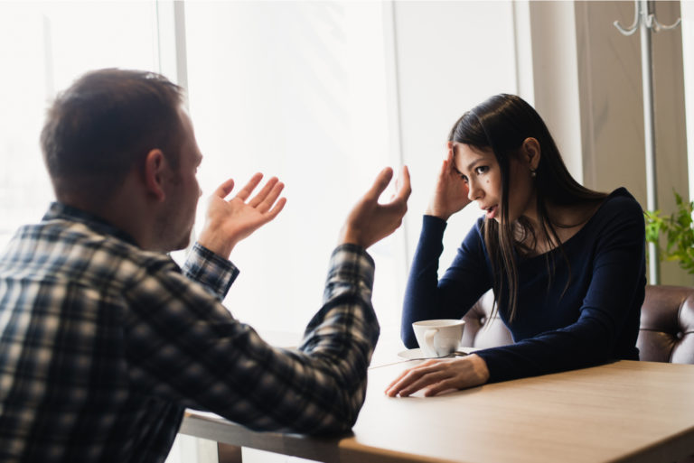 un homme et une femme sont assis à une table et parlent