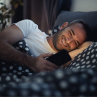 homme heureux couché dans son lit textos