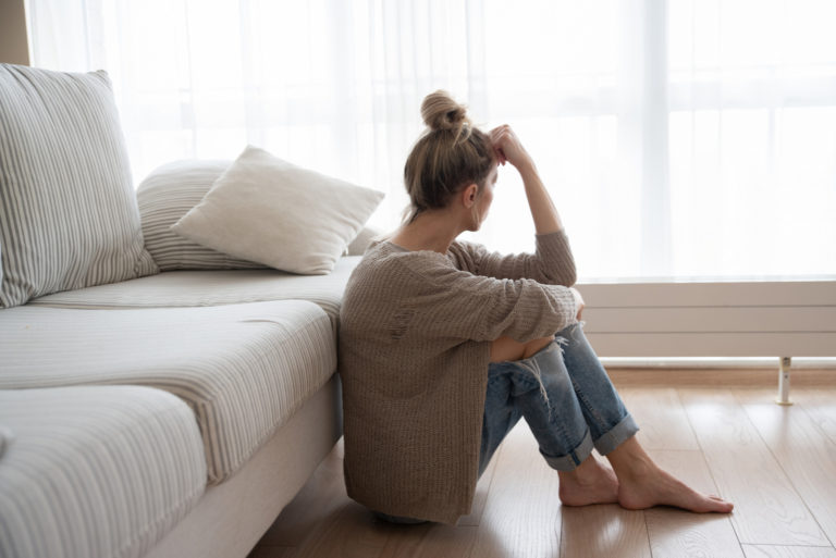 femme triste assise sur le sol