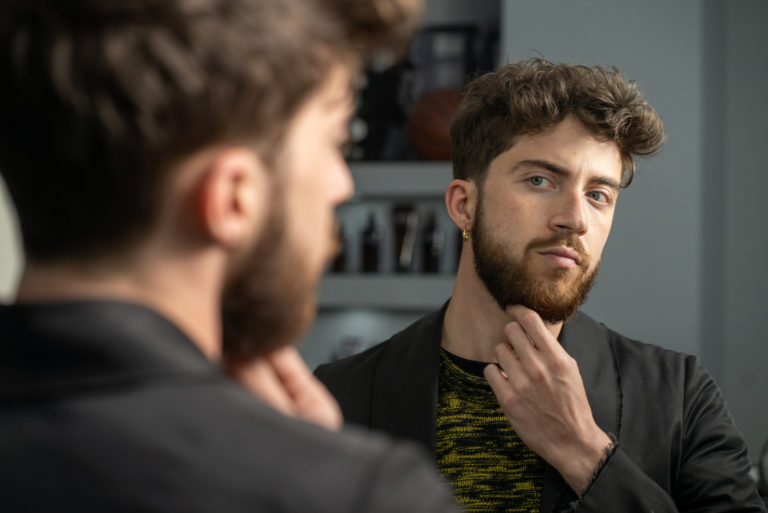 un homme debout devant un miroir