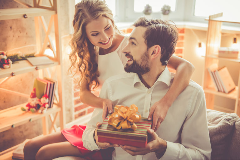 une belle femme offre un cadeau à un homme