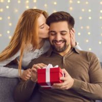 femme donnant un cadeau d'anniversaire à un homme et l'embrassant