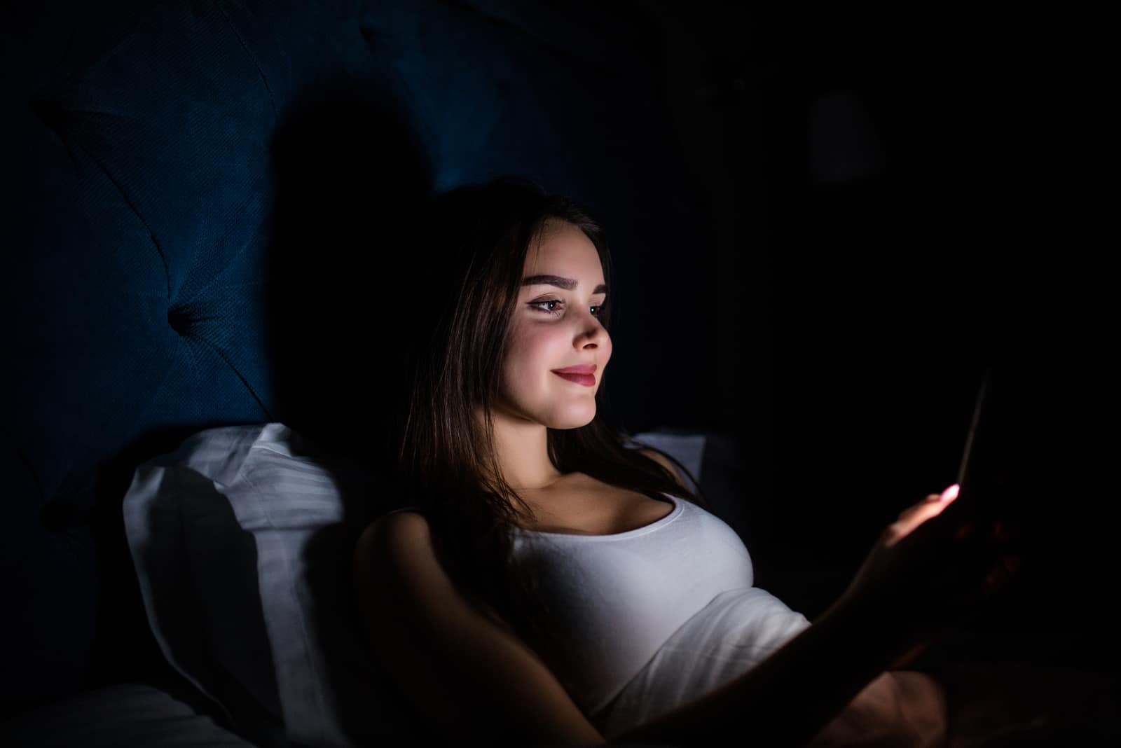 femme heureuse allongée dans son lit textos