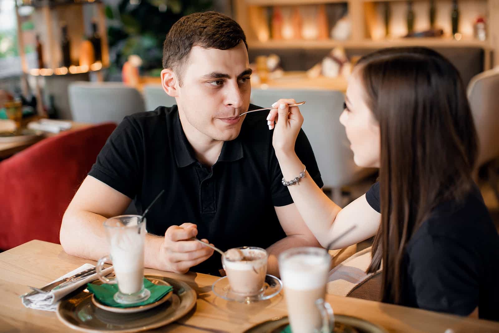 femme nourrissant un homme au café