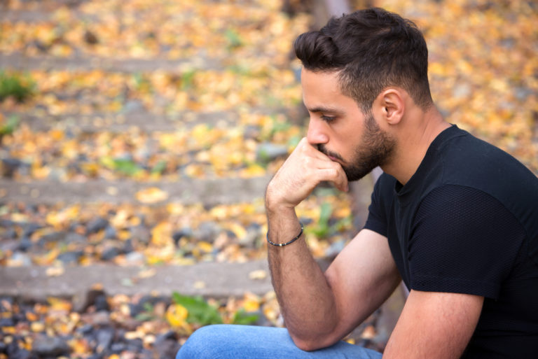 homme triste assis dans le parc