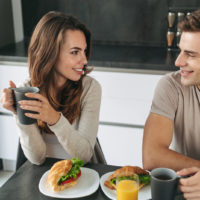 un homme et une femme assis à côté du petit déjeuner en train de parler