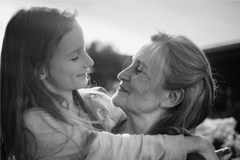 grand-mère tenant sa petite-fille et souriant
