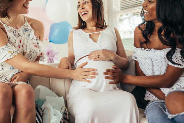 femme enceinte sur un canapé avec des amis