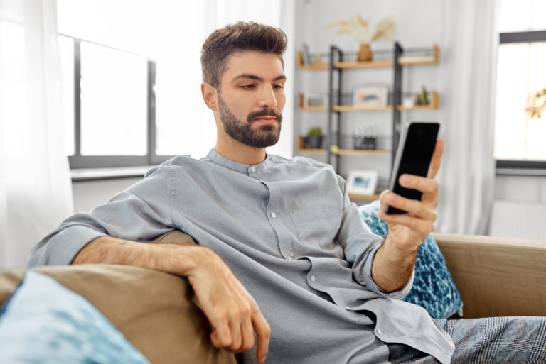 homme sérieux tape sur son téléphone