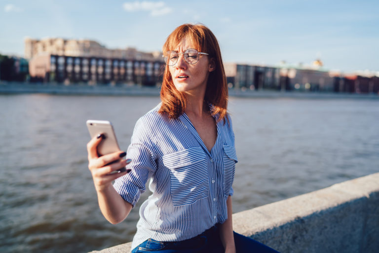 femme debout à l'extérieur de textos