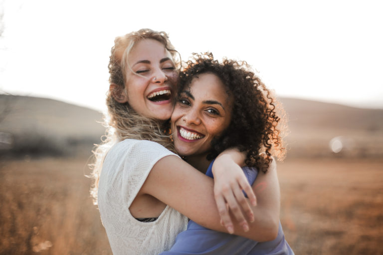deux meilleurs amis qui s'embrassent et sourient
