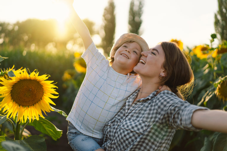 mère et fils s'embrassant dans le champ de tournesol