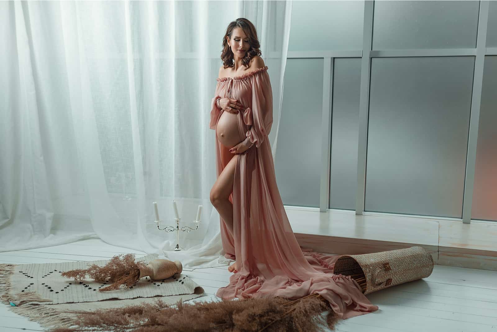 Séance photo de femme enceinte en robe rose