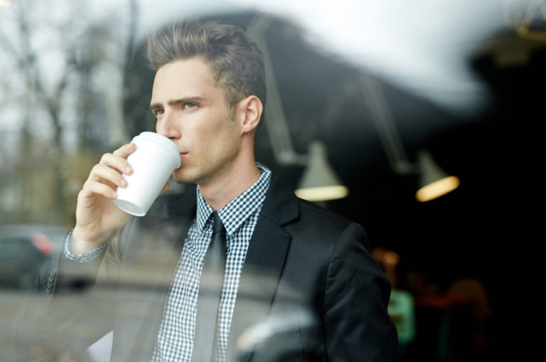 homme buvant du café regardant par la fenêtre