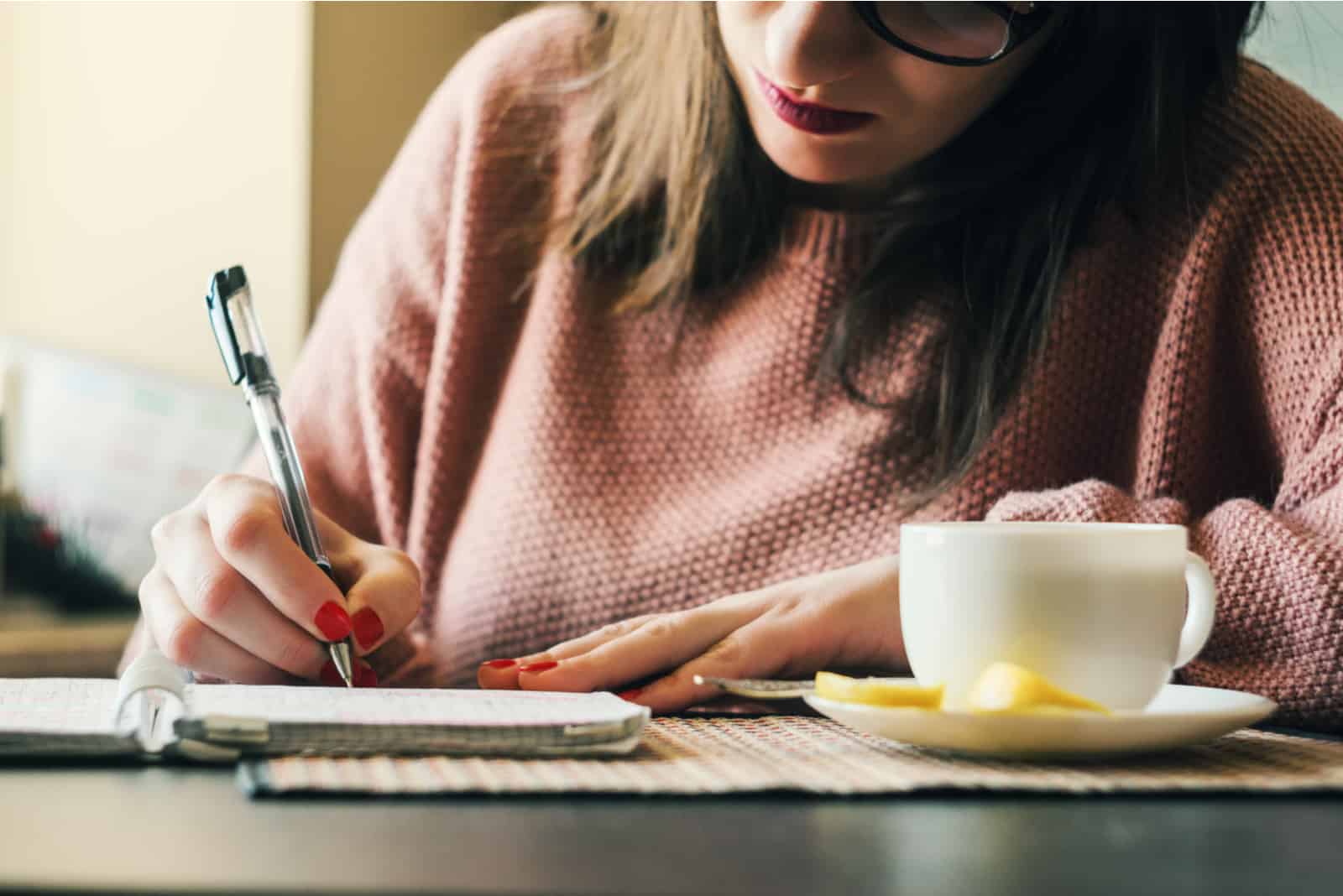 femme assise dans un café écrivant une note