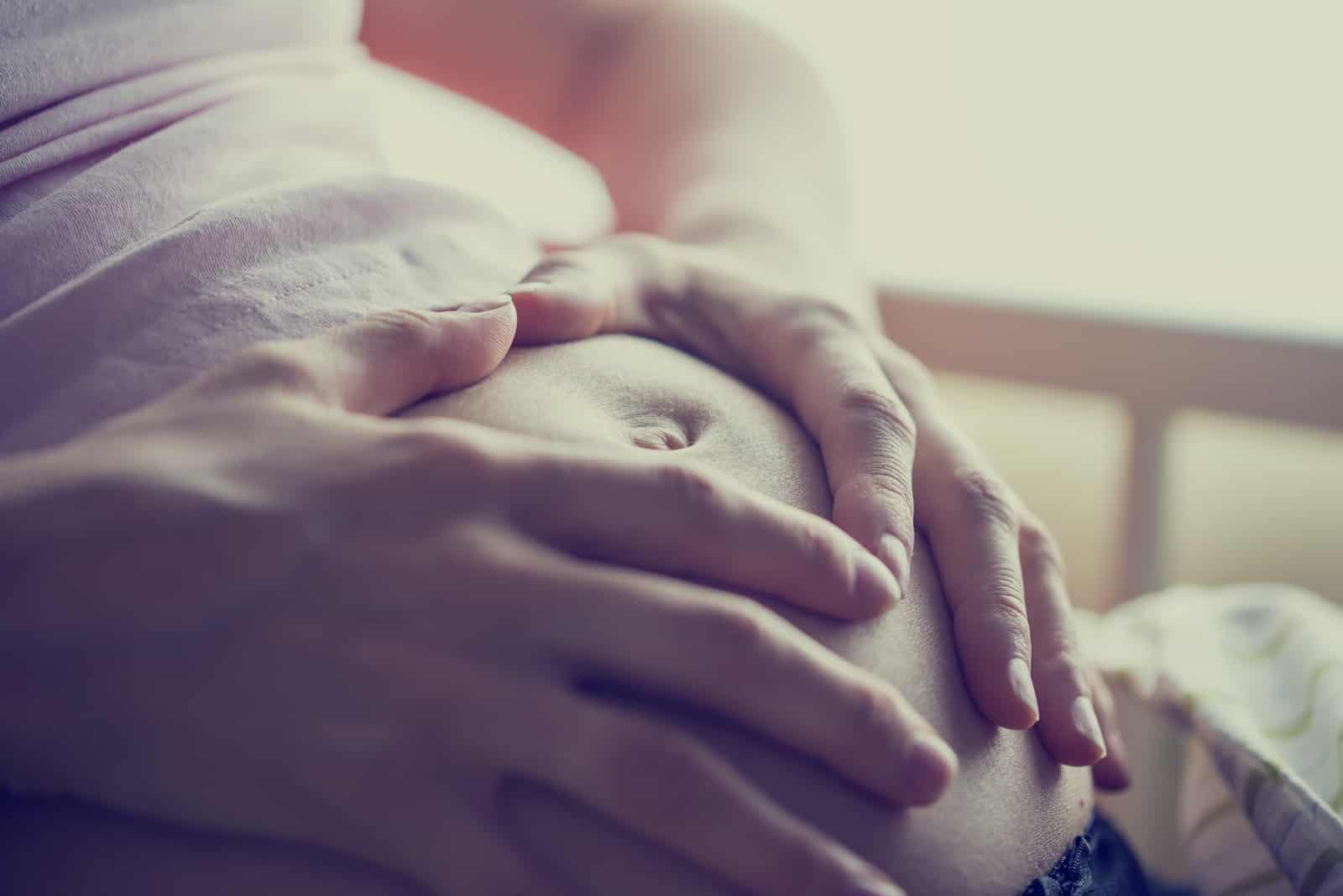 femme enceinte tenant le ventre