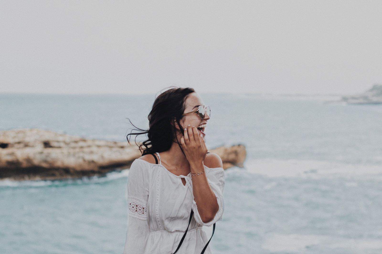 femme posant pour une photo devant l'océan