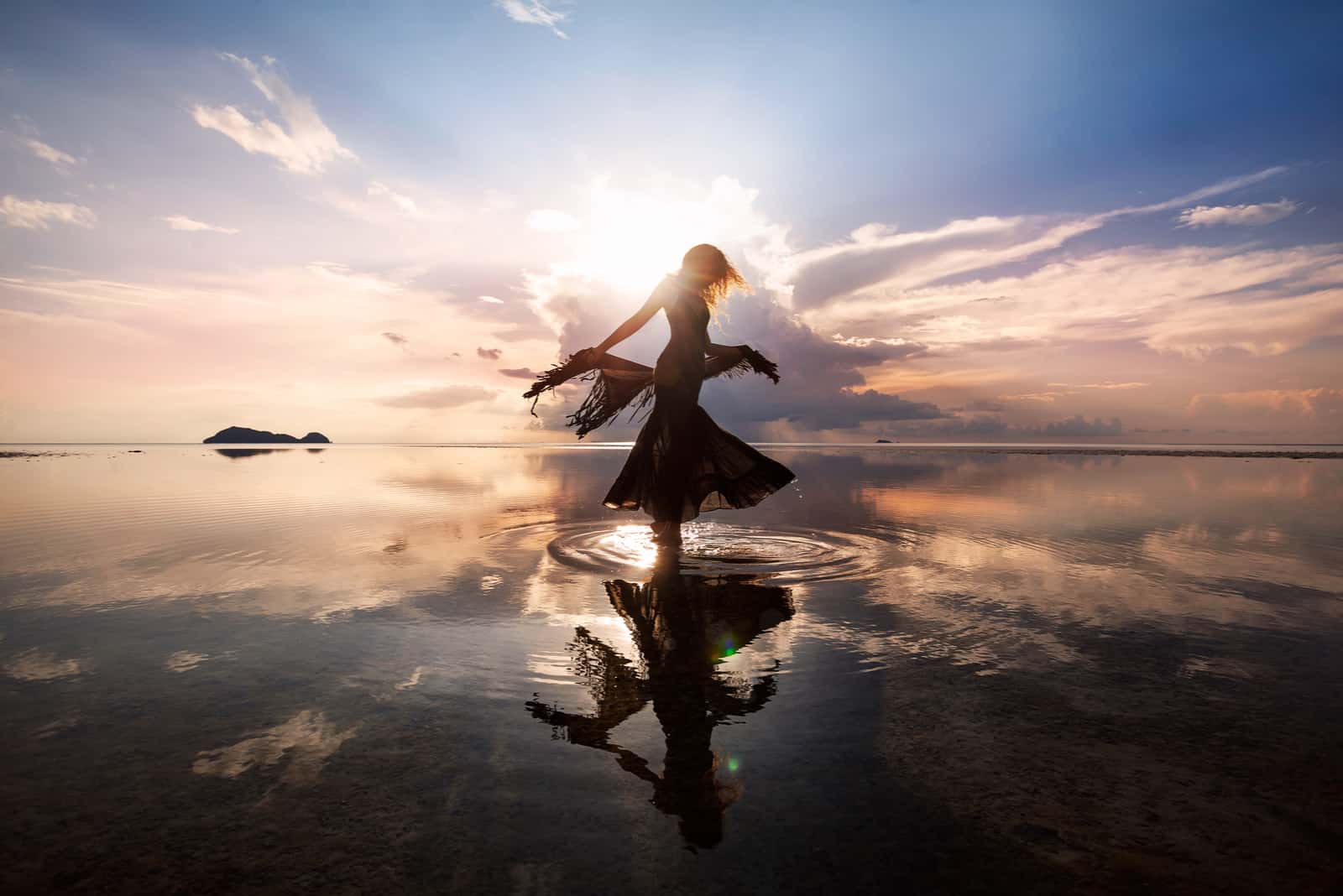 femme qui danse dans la mer au soleil