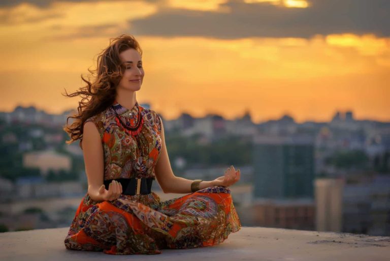 belle fille souriante en robe orange médite