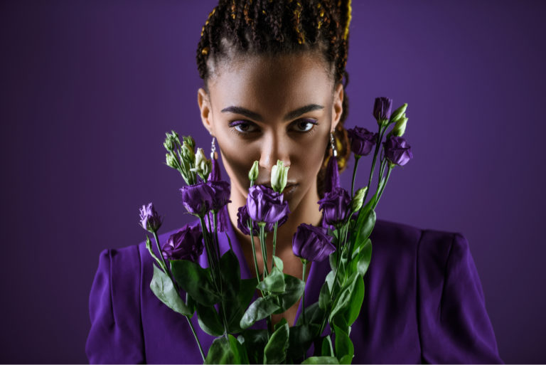 femme tenant des fleurs violettes
