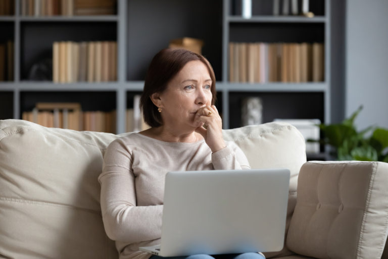 triste femme d'âge moyen assise sur un canapé