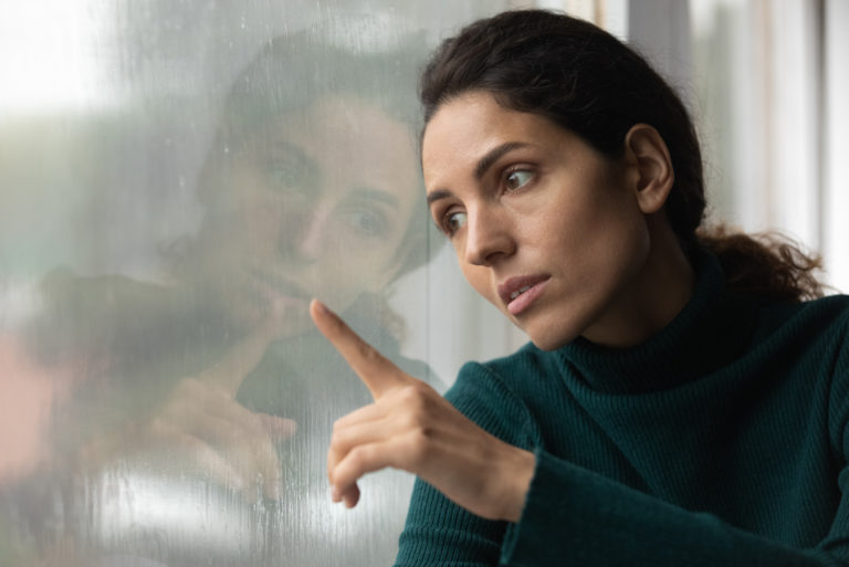 femme triste regardant par la fenêtre