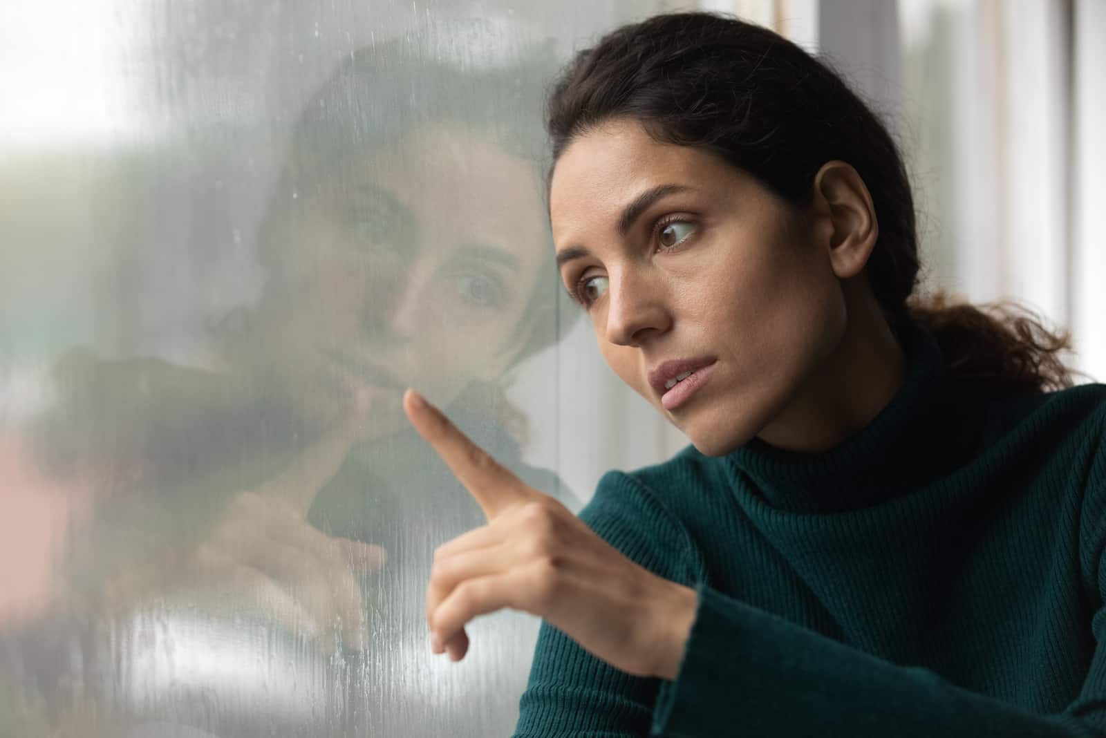 femme triste regardant par la fenêtre