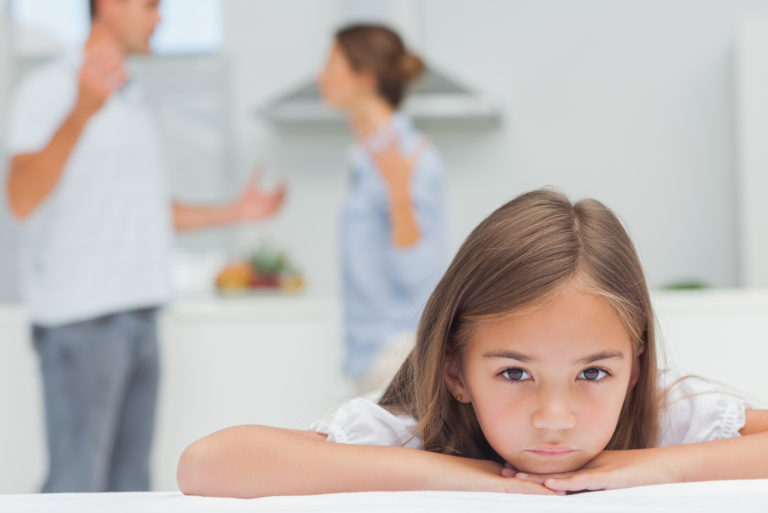 triste petite fille écoutant les parents se battre