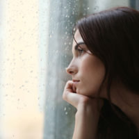 femme triste regardant par la fenêtre