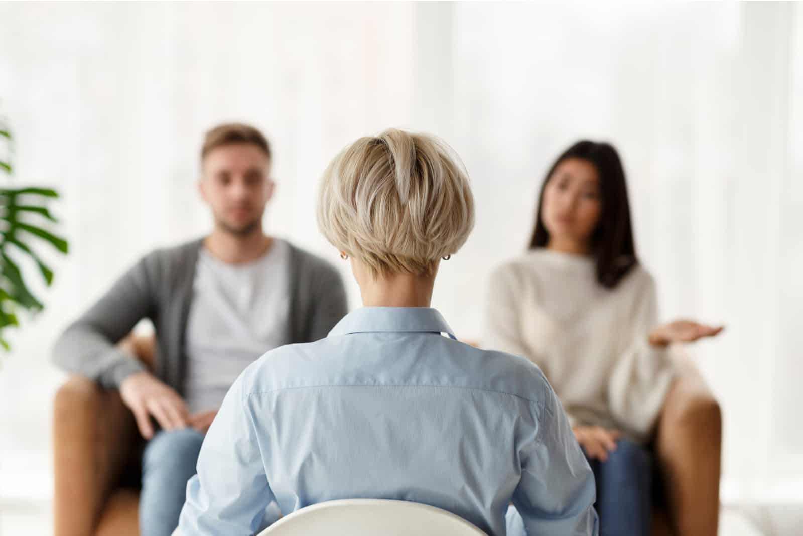 Psychologue assis avec un couple malheureux au bureau