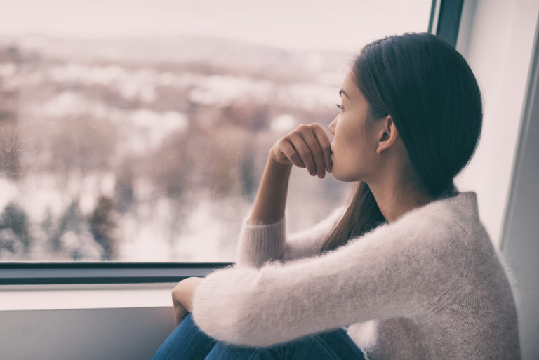 femme regardant par la fenêtre
