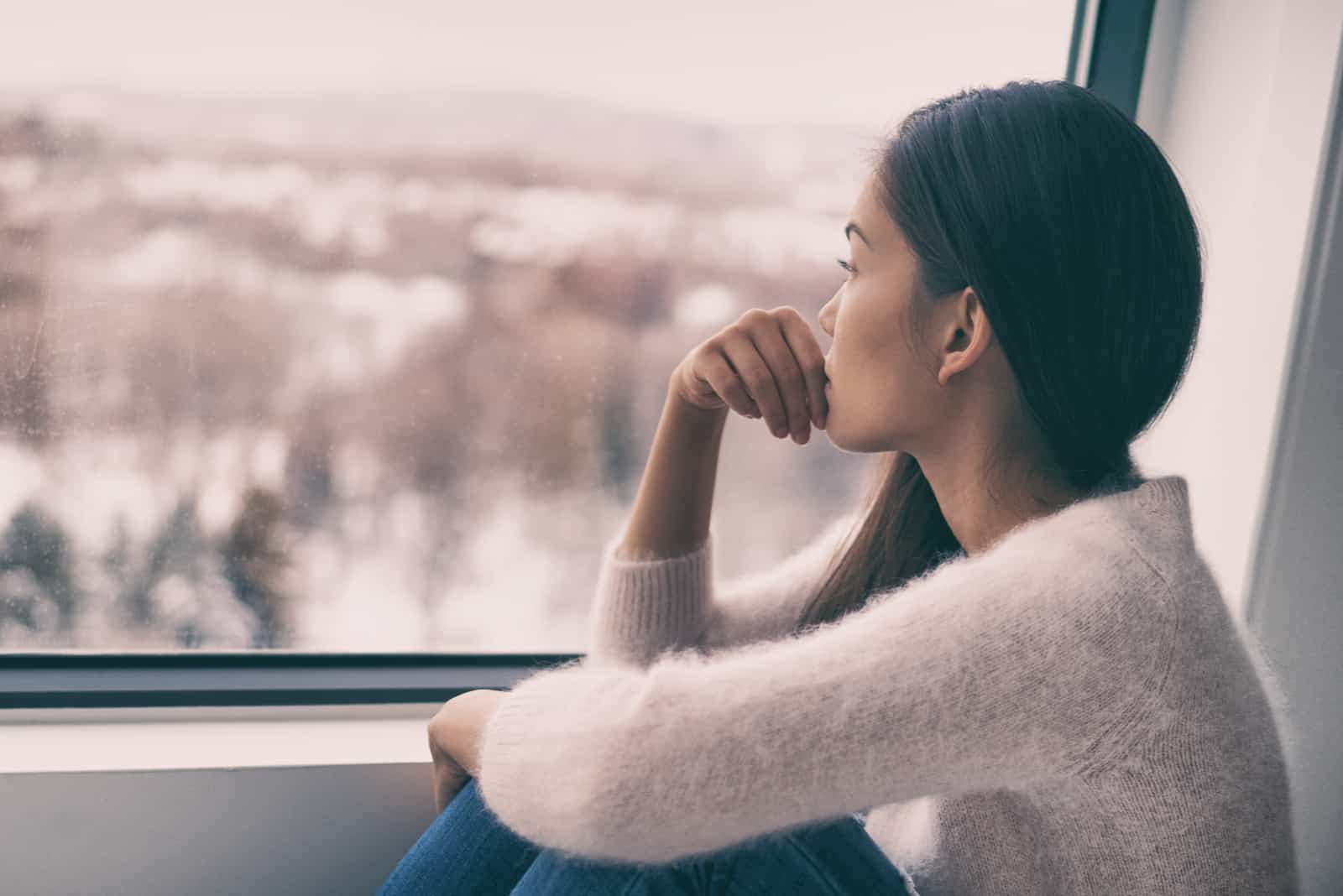 femme regardant par la fenêtre