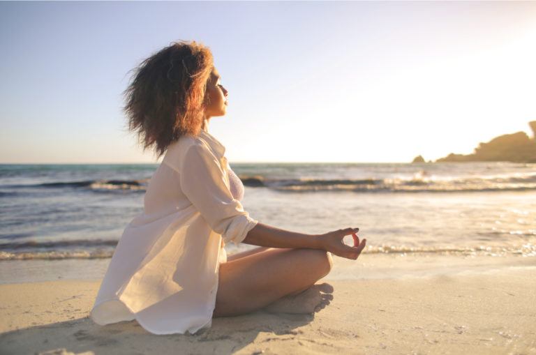 femme méditant sur la plage