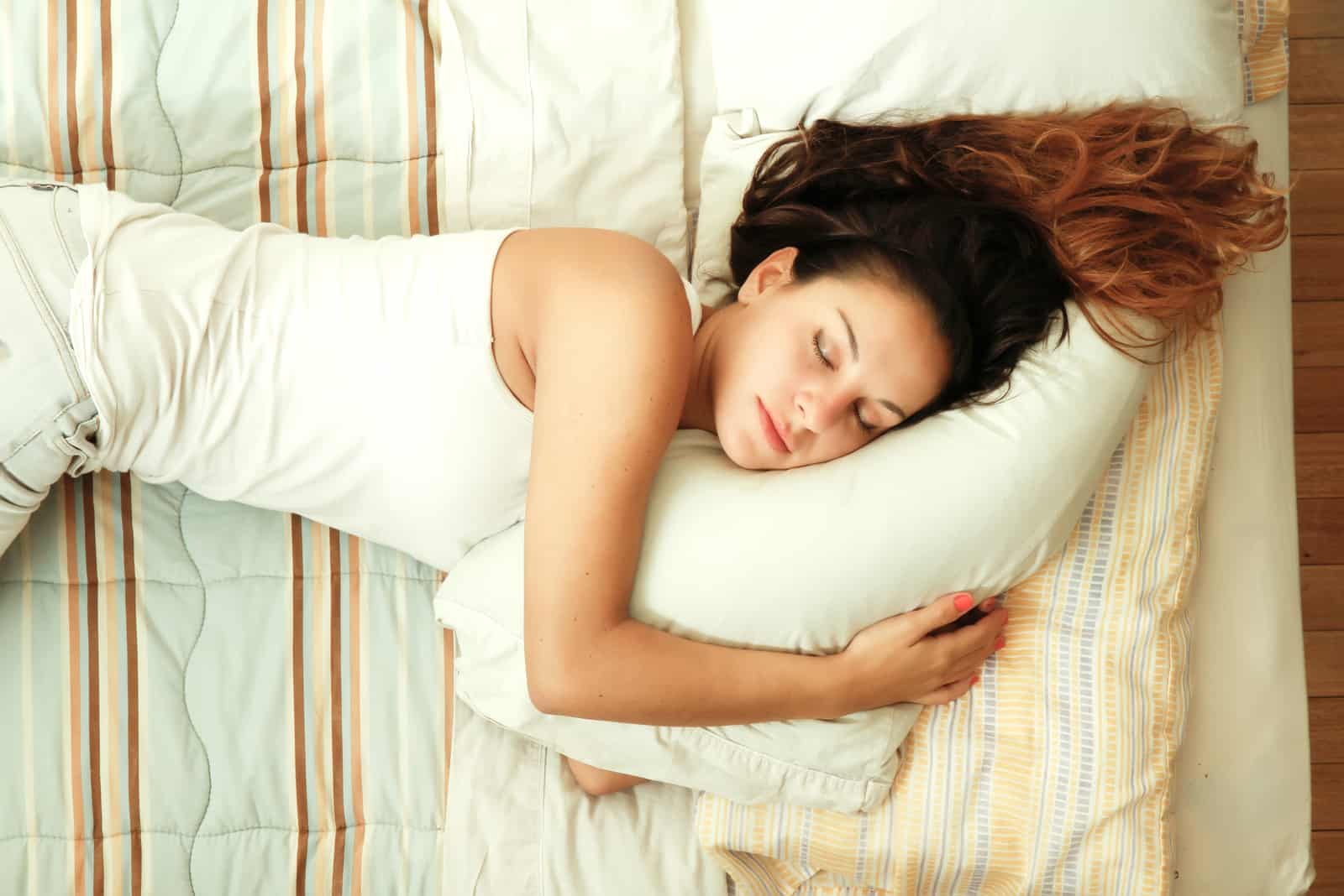 Une jeune femme qui dort sur le lit