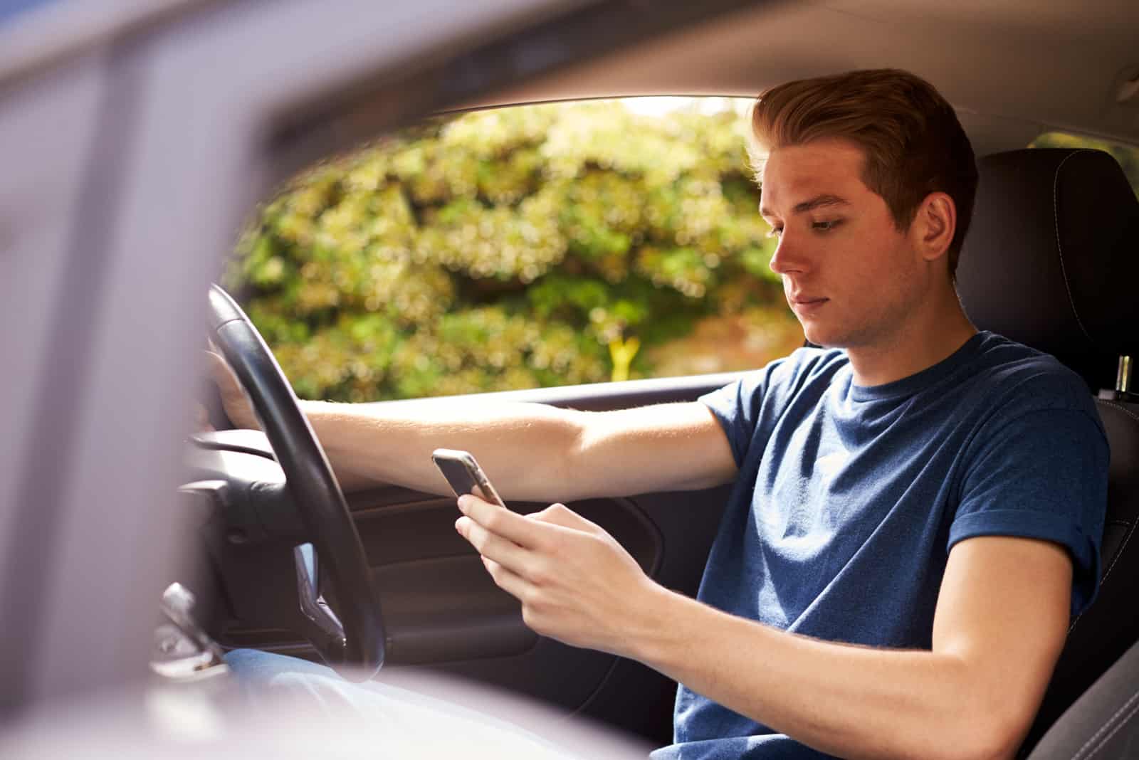 homme envoyant des SMS en conduisant une voiture
