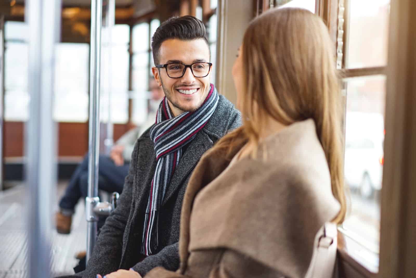 homme souriant à une femme dans le train