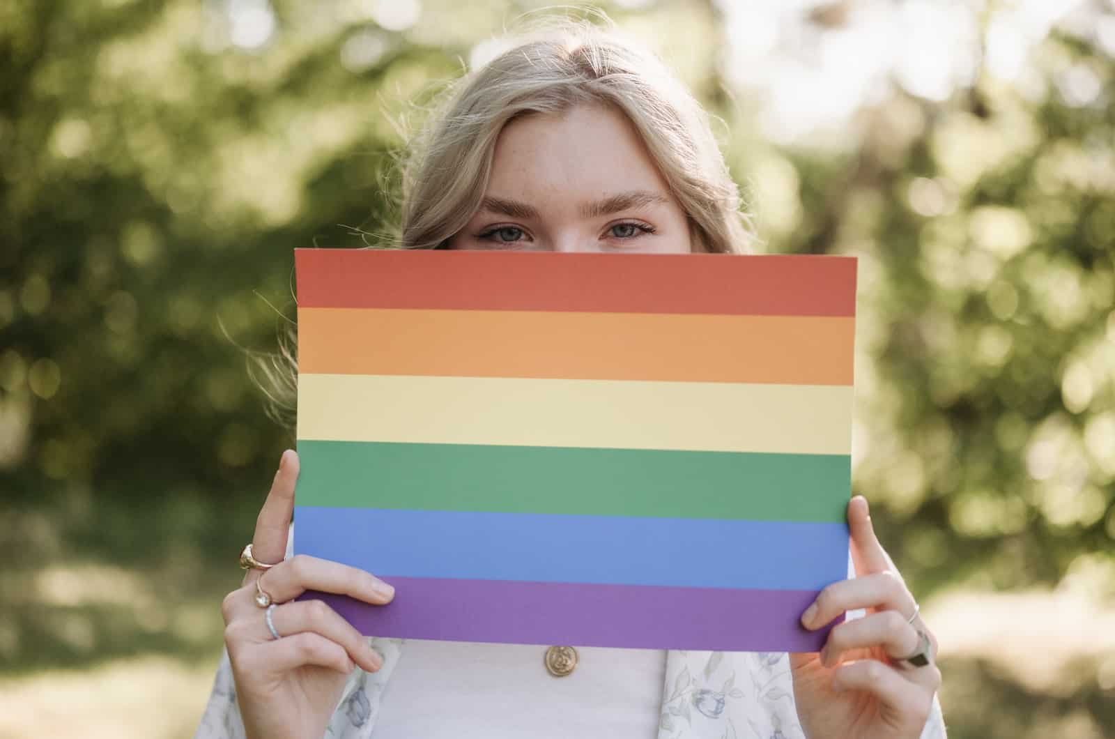 femme tenant un drapeau arc-en-ciel