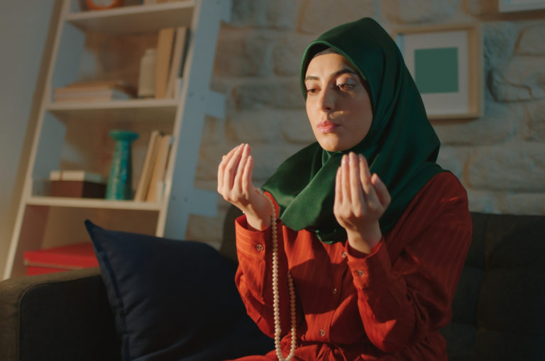 Femme musulmane priant Dieu dans sa maison