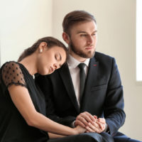 femme et homme en deuil lors d'un enterrement