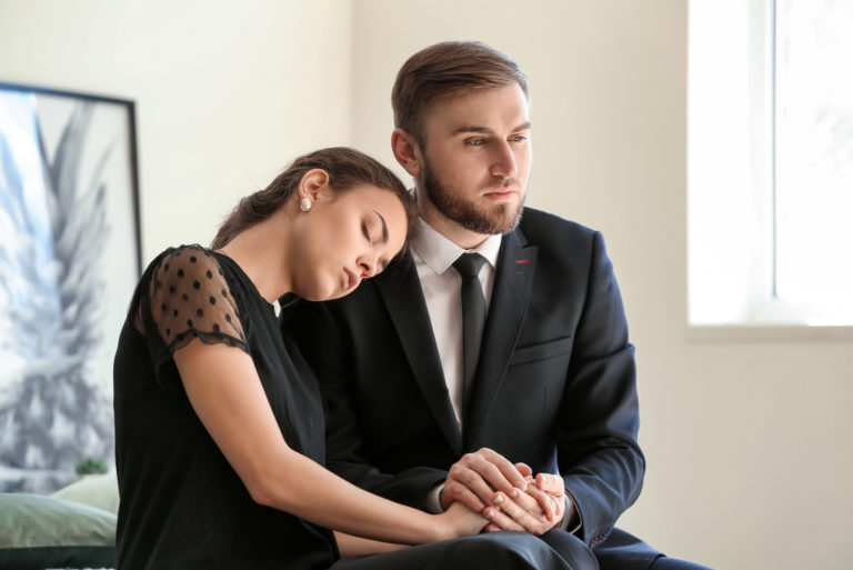 femme et homme en deuil lors d'un enterrement