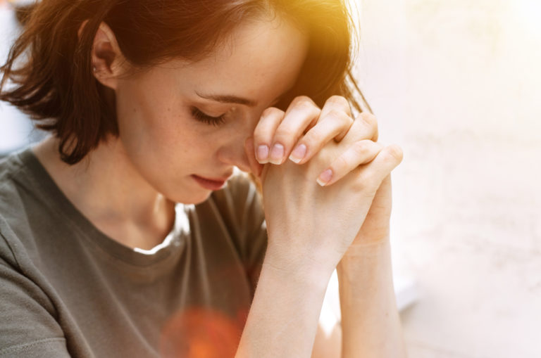 la femme la tête baissée prie