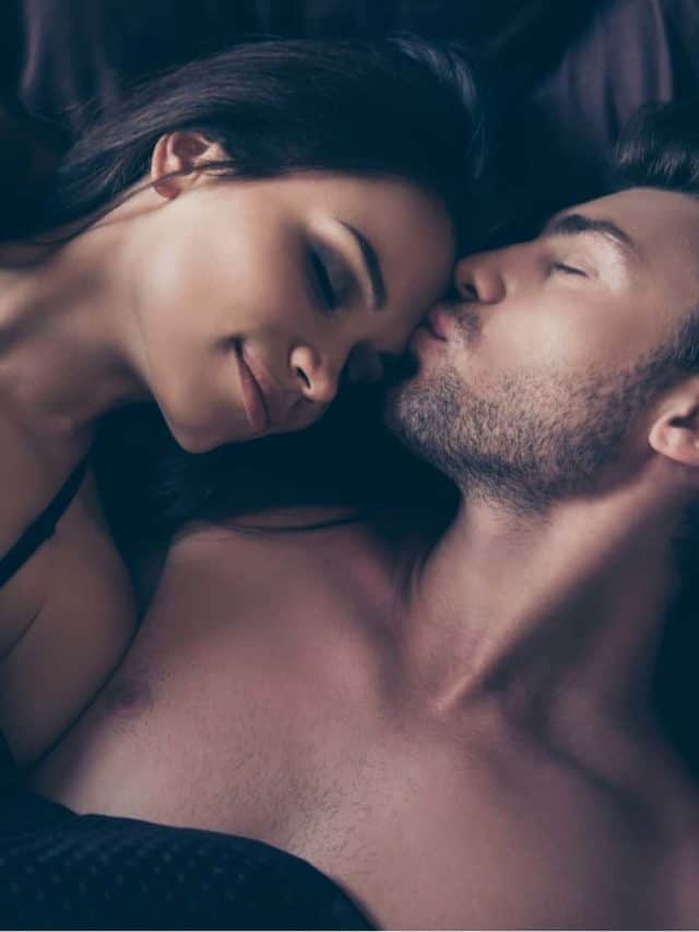 un homme embrasse une femme sur le front en position couchée dans son lit