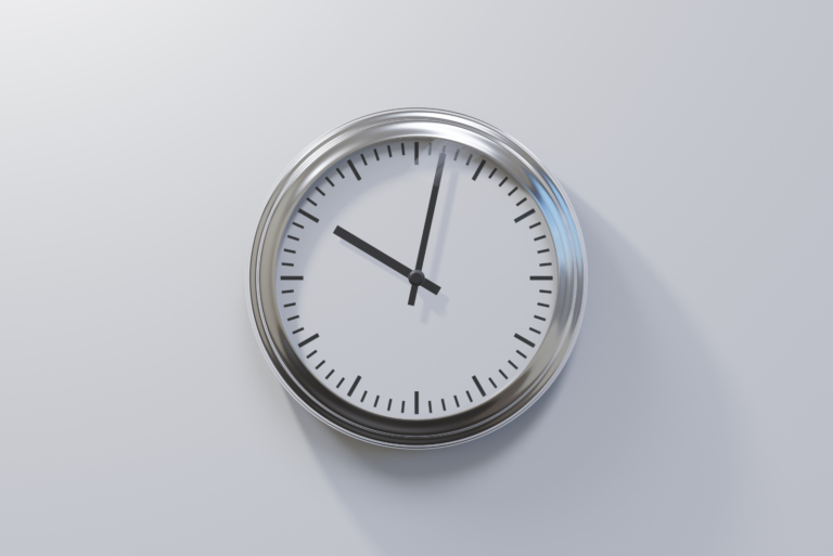 horloge grise sur un mur blanc
