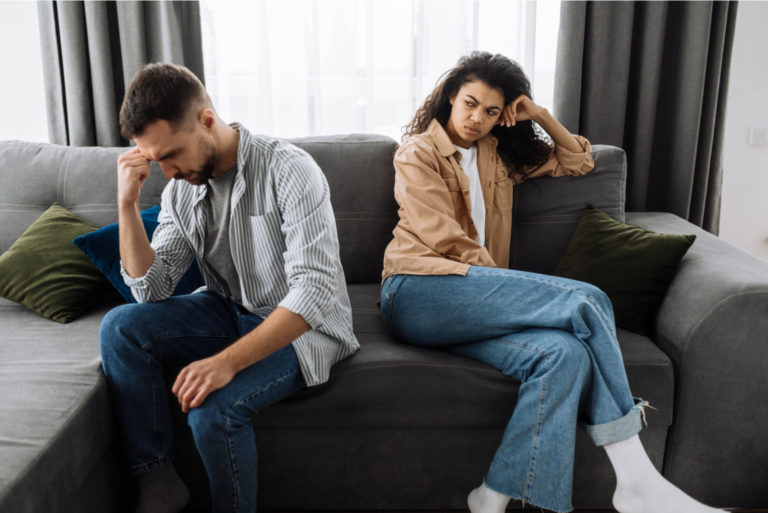couple en conflit assis sur le canapé