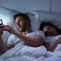 homme envoyant des textos au lit en ignorant sa femme